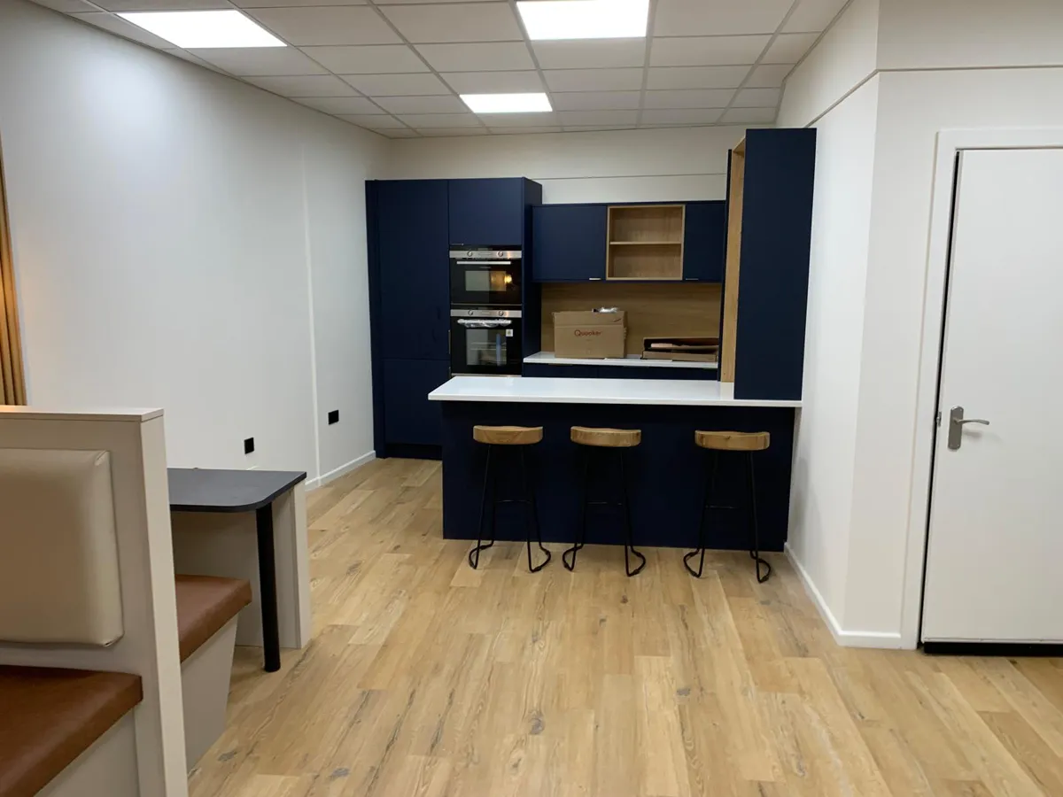 Handleless fitted kitchen with integrated appliances and stone worktop